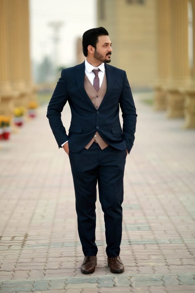 Stylish man in a navy suit stands confidently outdoors in Multan, Pakistan.