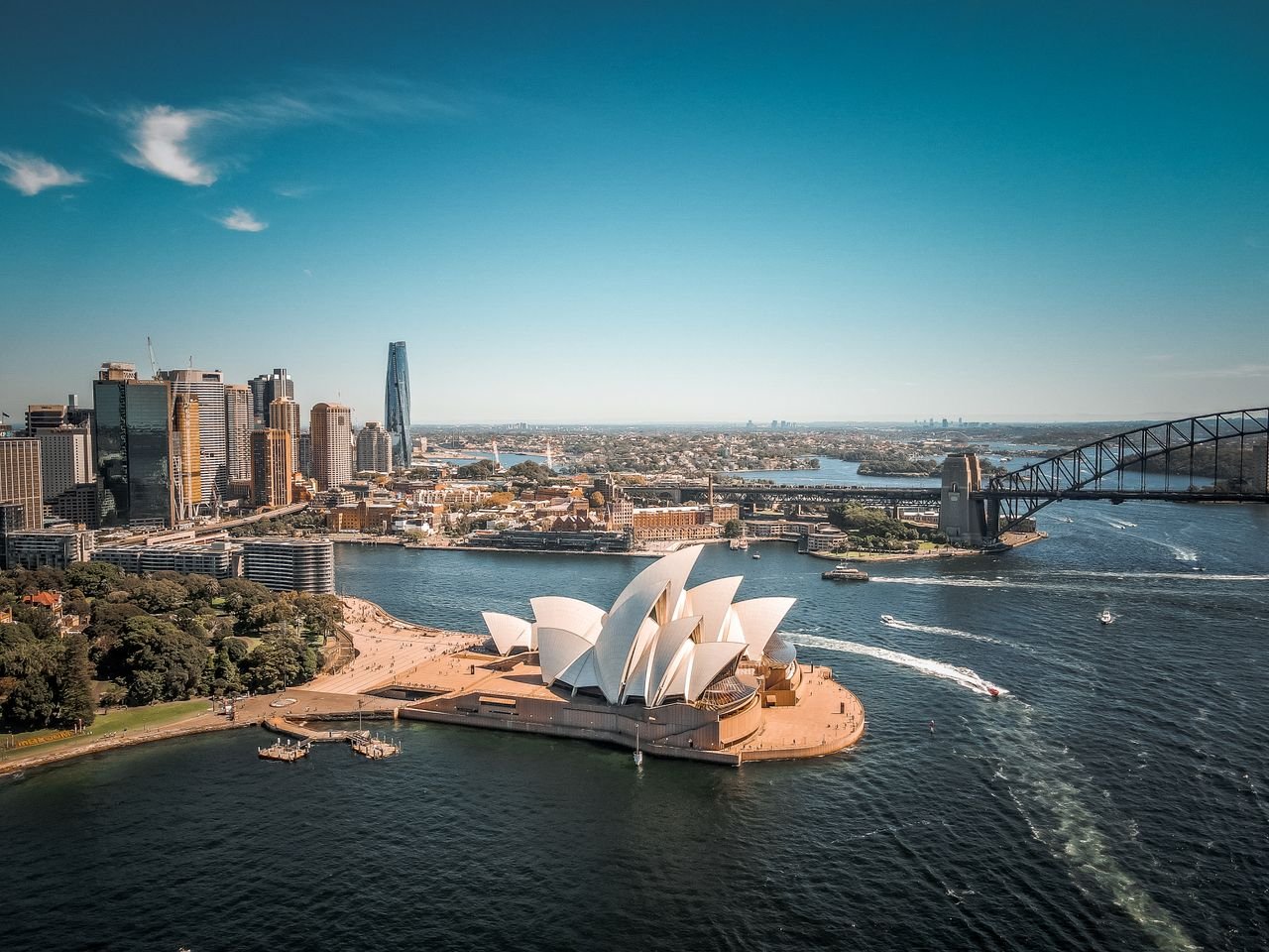 Fully Funded Scholarships in Australia for International Students 2027 Breathtaking aerial view of Sydney Opera House with surrounding skyline and Harbor Bridge.